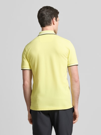 Männermodel trägt Slim Fit Poloshirt aus reiner Baumwolle Modell 'PAUL' von BOSS Green, Optik: Unifarben, Ganzkörperansicht Rückansicht.