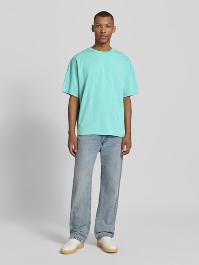 Männermodel trägt T-Shirt mit geripptem Rundhalsausschnitt Modell 'FIZVALLEY' von American Vintage in Türkis, lockerer Schnitt, Ganzkörperansicht von vorne.