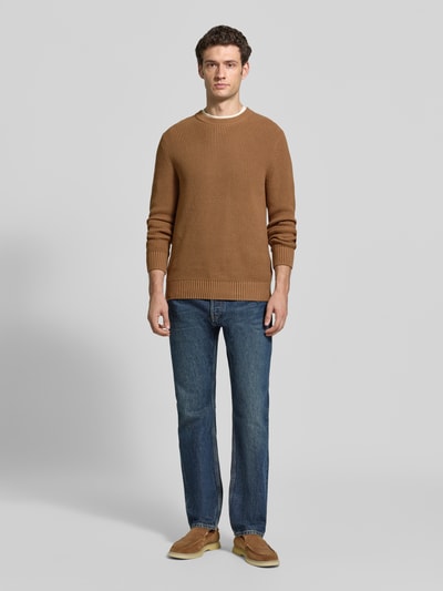 Männermodel trägt Regular Fit Strickpullover aus reiner Baumwolle von MCNEAL, braun, strukturierte Oberfläche, Rundhalsausschnitt, Ganzkörperansicht von vorne