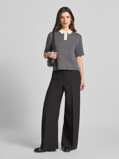 Frauenmodel trägt Strickshirt mit Polokragen Modell 'Tipolo' von Someday in Grau mit weißer Knopfleiste, Material-Mix mit Viskose-Anteil, Gerader-Schnitt, Rückenlänge 54 cm, Ärmellänge 25 cm, Ganzkörperansicht von vorne.