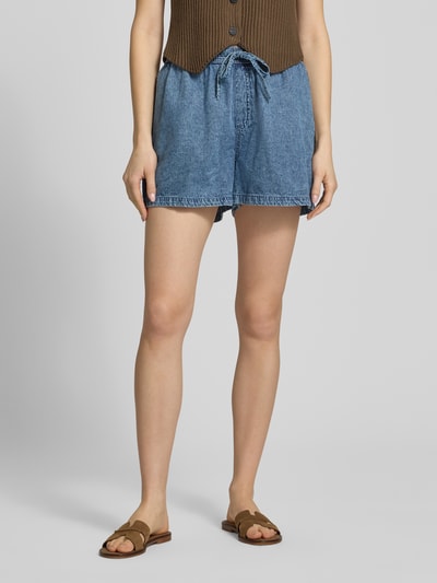 Frauenmodel trägt Shorts mit elastischem Bund Modell 'ENZA' von Noisy May aus Reine Baumwolle, Regular-Fit, blaue Jeansoptik, Ganzkörperansicht von vorne, Bundweite bei Größe S 36 cm, Innenbeinlänge 8 cm.