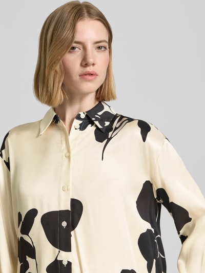 Vrouwenmodel draagt Regular fit overhemdblouse uit zuiver viscose model 'Zeoul' van Someday met bloemen all-over print, overhemdkraag, met lange mouwen, knoopsluiting, ruglengte maat 36: 69 cm, mouwlengte maat 36: 55 cm, nahaufnahme bovenlichaam.