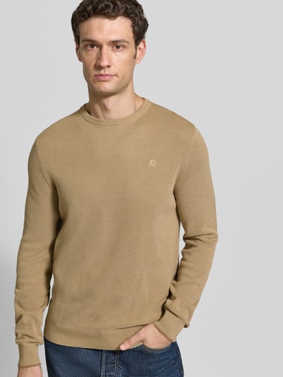 Männermodel trägt Regular Fit Strickpullover aus reiner Baumwolle mit Label-Detail von LERROS, beige Farbe, elastische Abschlüsse, Nahaufnahme Oberkörper, Kontext: Rückenlänge 68 cm, Ärmellänge 69 cm.