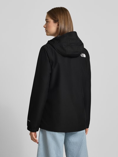 Frauenmodel trägt Regular Fit Funktionsjacke mit Logo-Print Modell 'Quest Mono' von The North Face in Schwarz, glatte Textur, Ganzkörperansicht Rückansicht. Damen Funktionsjacke, Kapuze, Reißverschluss, Rückenlänge 69 cm, Schulterbreite 40 cm, Brustweite 40 cm, Ärmellänge 63 cm.
