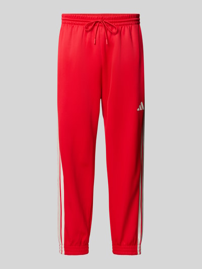Produktfoto, Sweatpants mit Logo und elastischem Bund von adidas Sportswear in Rot, Baumwoll-Mix, Regular Fit, Tunnelzug, glatte Textur.