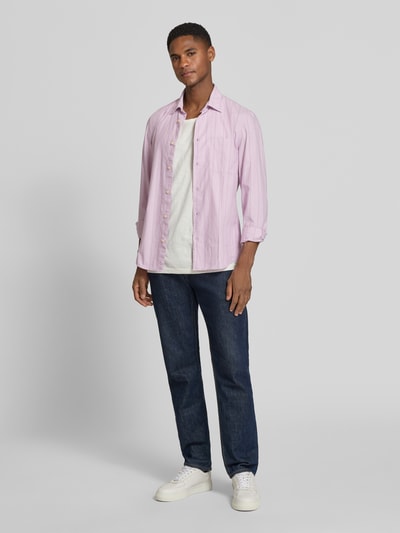 Männermodel trägt Shaped Fit Freizeithemd aus Baumwoll-Mix von Marc O'Polo in Rosa mit Kentkragen, gestreift, Popeline, Ganzkörperansicht von vorne.