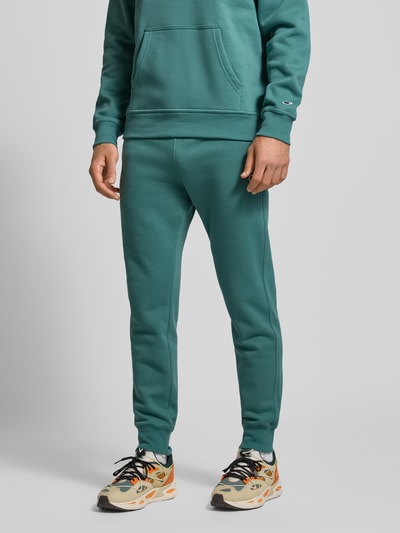 Männermodel trägt Sweatpants mit elastischem Bund und Label-Stitching von CHAMPION aus Baumwoll-Mix, Regular-Fit, Nahaufnahme Unterkörper.