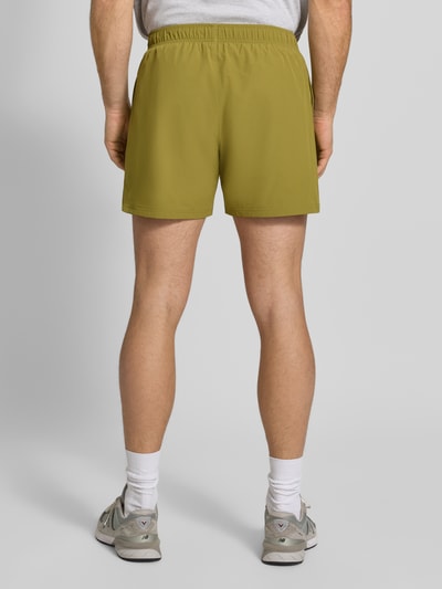 Männermodel trägt Shorts mit elastischem Bund von HALO in Olivgrün, Material-Mix mit Stretch, Regular Fit, Ganzkörperansicht Rückansicht.