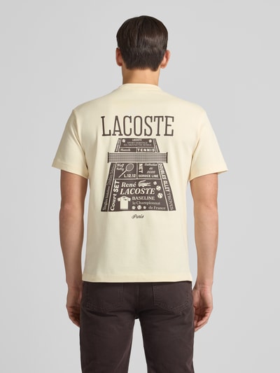 Mężczyzna model nosi Regular Fit T-Shirt aus reiner Baumwolle Modell 'LOURD' od Lacoste, jednolity kremowy kolor, krótki rękaw, widok całej sylwetki od tyłu.