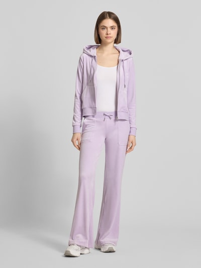 Vrouwenmodel draagt Low Rise Sweatpants met steekzakken model 'LAYLA' van Juicy Couture, lila, materiaalmix met stretch, elastische band, binnenbeenlengte maat S 82 cm, full body vooraanzicht.