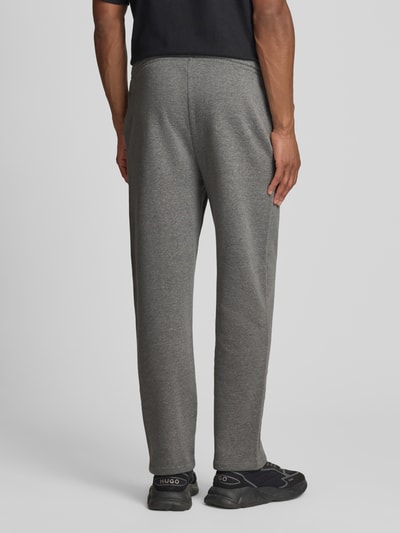 Männermodel trägt Sweatpants mit elastischem Bund und Logo von GAP aus Baumwoll-Mix, Regular-Fit, graue Farbe, Ganzkörperansicht Rückansicht. Innenbeinlänge bei Größe M: 74 cm.