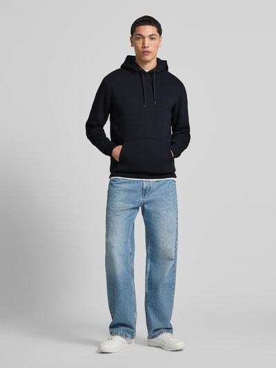 Männermodel trägt Regular Fit Hoodie aus Baumwoll-Mix Modell 'CERES' von Only & Sons, Optik: Unifarben, Kängurutasche, Ganzkörperansicht von vorne.