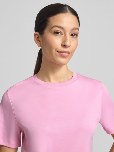 Frauenmodel trägt Basic T-Shirt mit Rundhalsausschnitt von Christian Berg Woman in Rosa, reine Baumwolle, unifarben, Nahaufnahme Oberkörper.