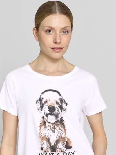 Frauenmodel trägt Regular Fit T-Shirt mit Ziersteinbesatz von monari, Weiß mit Motiv-Print, Baumwoll-Modal-Mix, Rundhalsausschnitt, Nahaufnahme Oberkörper.