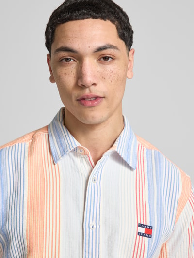 Männermodel trägt Relaxed Fit Freizeithemd aus reiner Baumwolle von Tommy Jeans, Optik:Allover-Muster, gestreift, Nahaufnahme Oberkörper.