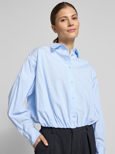 Frauenmodel trägt Cropped Bluse mit Hemdblusenkragen Modell 'Emmana' von Neo Noir in Hellblau, reine Baumwolle, Nahaufnahme Oberkörper.