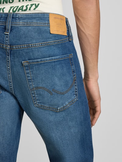 Mężczyznamodel nosi Straight Fit Jeans im 5-Pocket-Design Modell 'Clark' von Jack & Jones w niebieskim, mieszanka bawełny elastycznej, zapięcie na guzik i zamek błyskawiczny, szerokość w rozmiarze 32/32: 44 cm, długość wewnętrzna nogawki 74 cm, widok z tyłu w zbliżeniu na kieszeń.