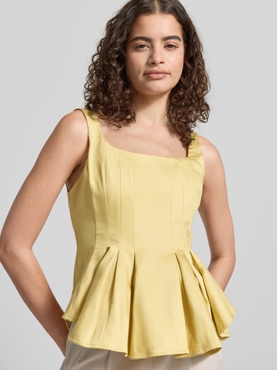 Kobiece model prezentuje top z mieszanki lyocellu o wyglądzie denimu, model 'Fatima' od Topshop, taliowany krój, bez rękawów, kolor jasny żółty, długość tyłu w rozmiarze 36: 43 cm, krótki fason, wyraźne przeszycia, gładka tekstura, damski top z mieszanki lyocellu i lnu, zdjęcie w ujęciu z przodu, zbliżenie górnej części ciała.