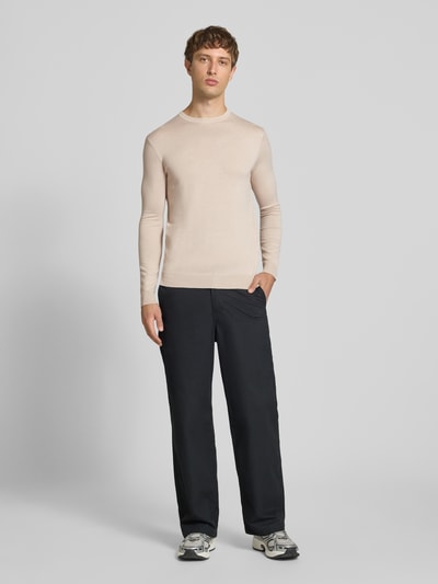 Männermodel trägt Regular Fit Pullover aus Viskose-Mix Modell 'WYLER' von ONLY & SONS in Beige, glatte Textur, Ganzkörperansicht von vorne.