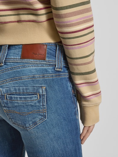 Frauenmodel trägt Skinny Fit Jeans aus Baumwoll-Mix Modell 'GEN' von Pepe Jeans in Blau mit Label Patch, Detailaufnahme Rückansicht.