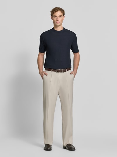 Männermodel trägt Slim Fit Strickshirt aus reiner Wolle von Emporio Armani in Dunkelblau, kurze Ärmel, Ganzkörperansicht von vorne.