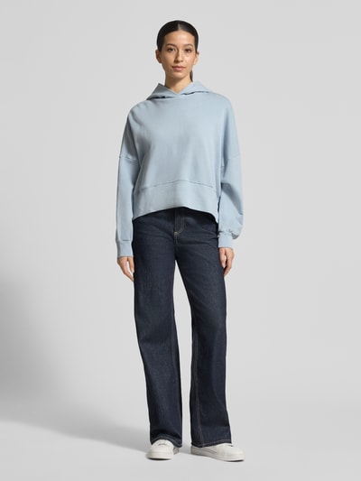 Frauenmodel trägt Relaxed Fit Hoodie aus reiner Baumwolle von Marc O'Polo, Optik: Unifarben, Passform: Relaxed-Fit, Label-Print, Kapuze, Langarm, Materialverarbeitung: Sweat, Bündchen: gerippt, Ganzkörperansicht von vorne.