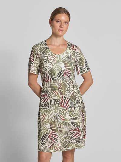 Frauenmodel trägt Knielanges Kleid im Allover-Look mit Rundhalsausschnitt von MORE & MORE, florale Muster in Grün, Rot, Beige, A-Linie, Material-Mix mit Stretch-Anteil, Ganzkörperansicht von vorne.