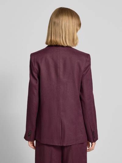 Frauenmodel trägt Blazer mit Pattentaschen Modell 'TEMPOLI' von Mango aus Reinem Leinen in dunklem Bordeaux, Gerader-Schnitt, Ganzkörperansicht Rückansicht. Rückenlänge bei Größe S: 69 cm, Brustweite: 35 cm, Ärmellänge: 62 cm, Knopfverschluss und Reverskragen sind sichtbar, glatte Textur.