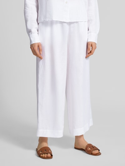 Kobieta modelka nosi białe, szerokie spodnie z lnu od MM by Max Mara Culotte aus Leinen mit elastischem Bund Modell 'CANNETI', szerokość w rozmiarze 36: 36 cm, długość nogawki wewnętrznej: 67 cm, krój wide leg fit, kieszenie francuskie, detaliczna faktura tkaniny, widok na całe nogi z przodu
