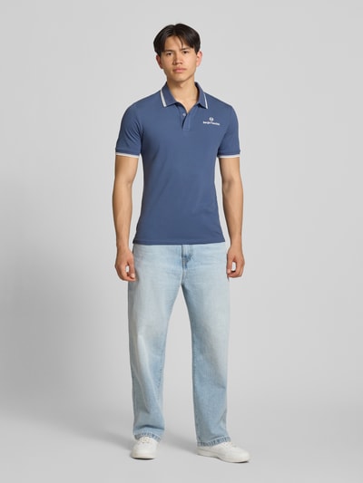 Männermodel trägt Slim Fit Poloshirt mit Logo-Stitching Modell 'Reed' von SERGIO TACCHINI, Baumwoll-Mix, Ganzkörperansicht von vorne.