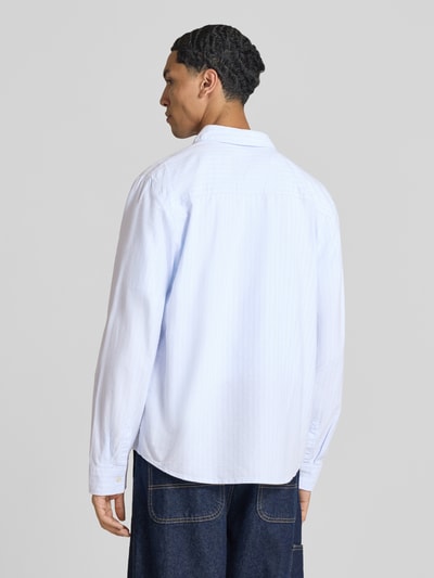 Männermodel trägt Regular Fit Freizeithemd aus reiner Baumwolle von REVIEW, hellblaue Farbe, Langarm, Rückenansicht, KI-modifiziertes Bild.
