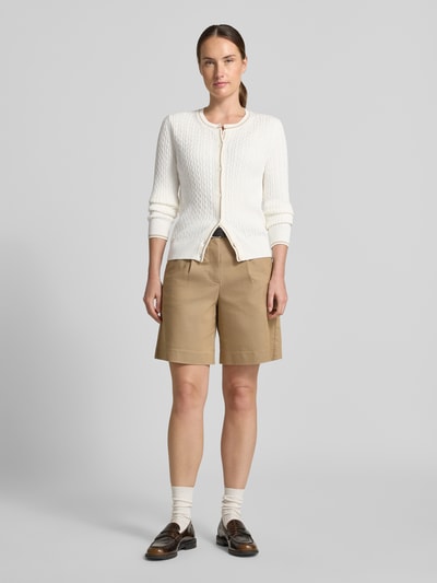 Frauenmodel trägt Regular Fit aus Baumwoll-Mix von Lacoste, weiß strukturiert, kombiniert mit beigefarbenen Shorts, Ganzkörperansicht von vorne. Damen Strickjacke von Lacoste.