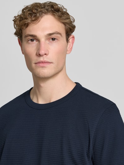 Männermodel trägt Regular Fit T-Shirt aus reiner Baumwolle Modell 'COOPER' von SELECTED HOMME, Optik: Unifarben, Struktur, Nahaufnahme Oberkörper.