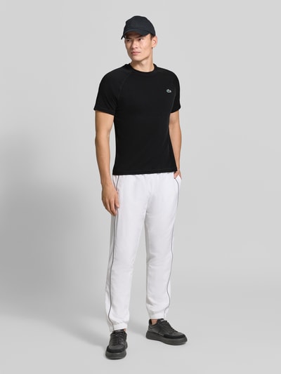 Männermodel trägt schwarzes Regular Fit Sport-T-Shirt mit Logo-Detail von Lacoste, Herren Sport-T-Shirt, Ganzkörperansicht von vorne