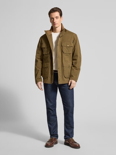 Männermodel trägt Regular Fit Jacke aus Baumwoll-Mix Modell 'SANDERLING' von Barbour in Olivgrün mit Stehkragen, Ganzkörperansicht von vorne.