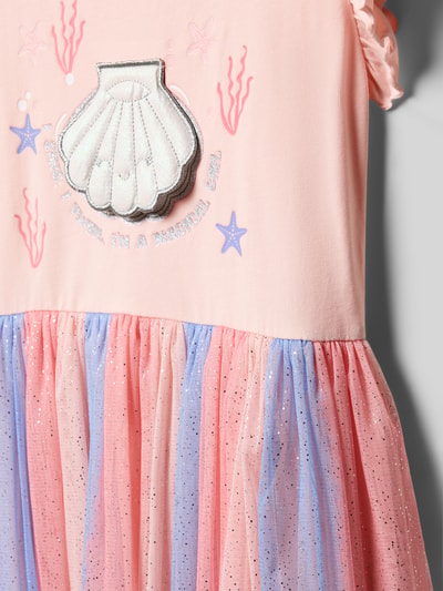 Mädchen trägt Regular Fit Kleid mit Statement-Print von DANAMADE aus Baumwoll-Mix mit Mesh und Falten-Optik, Nahaufnahme Oberkörper.