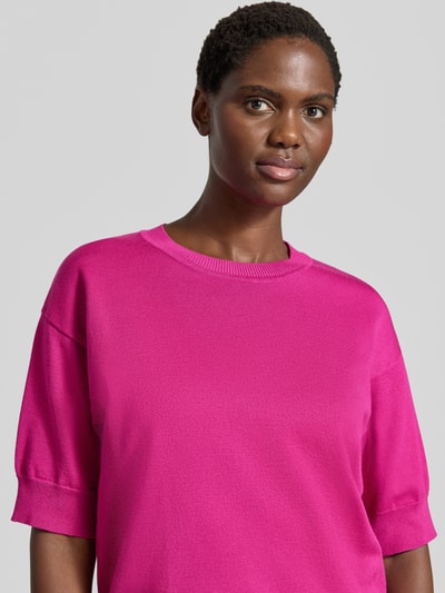 Modelka kobieca ma na sobie Relaxed Fit T-Shirt aus Viskose-Mix od b.young w intensywnym różu, prążkowane wykończenia, okrągły dekolt, rękaw o dł. 1/2, damski t-shirt z mieszanki wiskozy, długość tyłu 56 cm, długość rękawów 24 cm, widok z przodu, zbliżenie na górną część ciała.