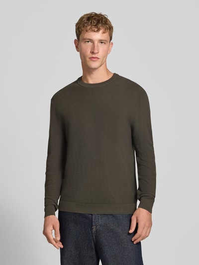 Männermodel trägt Regular Fit Pullover aus reiner Baumwolle Modell 'TONY' von ONLY, Olivgrün, strukturierte Oberfläche, Ganzkörperansicht von vorne. Herren Pullover von ONLY & SONS.