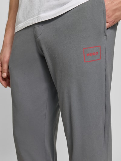 Männermodel trägt graue Regular Fit Sweathose aus Baumwoll-Mix Modell 'Laze Pants CW' von HUGO, Nahaufnahme Oberkörper, Herren Sweathose von HUGO.