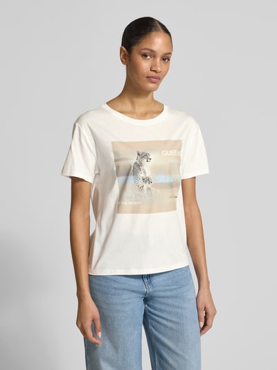 Frauenmodel trägt Regular Fit T-Shirt mit Strasssteinbesatz von monari aus reiner Baumwolle mit Motiv-Print, kurzärmelig, Rundhalsausschnitt, Rückenlänge bei Größe 36: 55 cm, helle Farben, weiche Textur, Ganzkörperansicht von vorne.
