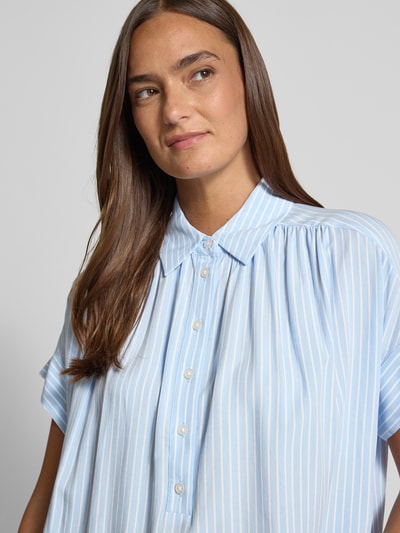 Frauenmodel trägt Relaxed Fit Bluse aus Viskose Modell 'Zafine' von Someday mit Hemdblusenkragen und Knopfleiste, Reine Viskose, Nahaufnahme Oberkörper.