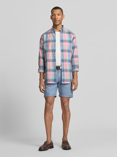 Männermodel trägt Bermudas mit Gürtel und Eingrifftaschen von MCNEAL in Hellblau, kombiniert mit Hemd, Straight Fit, Ganzkörperansicht von vorne. Baumwoll-Mix mit Stretch, seitliche Eingrifftaschen, Saum mit Aufschlag, Gesäßleistentaschen, Bundweite 46 cm, Innenbeinlänge 20 cm.