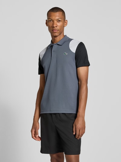 Männermodel trägt Regular Fit Sport-T-Shirt im Colorblock-Design von Lacoste in Grau, Schwarz und Weiß, Herren Sport-T-Shirt von Lacoste Sport, Ganzkörperansicht von vorne.