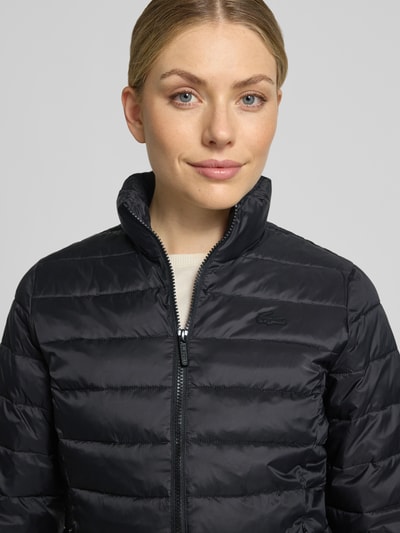 Vrouwenmodel draagt zwarte gewatteerd jack Slim Fit Steppjacke met logo-detail van Lacoste, Dames, Nahaufnahme bovenlichaam