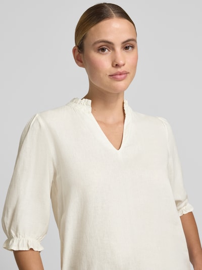 Frauenmodel trägt Bluse aus Leinen-Mix mit Puffärmeln Modell 'FALAKKA' von B.Young, Serafino-Kragen, 3/4-Arm, Straight Fit, Nahaufnahme Oberkörper. Leinen-Viskose-Anteil sorgt für leichte Textur, Rückenlänge 59 cm, Ärmel 34 cm, dezente Cremefarbe.