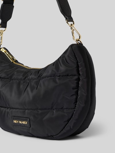 Produktfoto, Shoulder Bag in Stepp-Optik Modell 'Buddy' von Hey Marly in Schwarz, sichtbar sind Logo-Detail und abnehmbarer Schulterriemen, Hauptfach mit Reißverschluss, Maße 28x21x8 cm, Länge Schulterriemen 71 cm, strukturierte, glatte Oberfläche