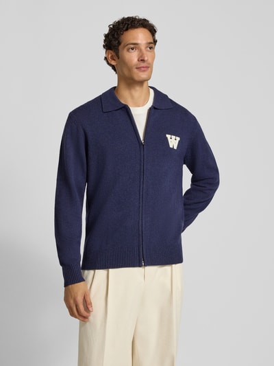 Mannelijk model draagt wollen cardigan uit zuiver wol met tweewegritssluiting, regular fit, labeldetail, Model 'Tay' van Wood Wood, ruglengte maat M 68 cm, mouwlengte maat M 73 cm, voorkant volledig in beeld