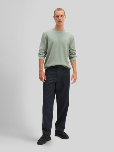 Männermodel trägt Regular Fit Pullover aus reiner Baumwolle von Marc O'Polo in zartem Grün, glatt, feine Struktur, Ganzkörperansicht von vorne.