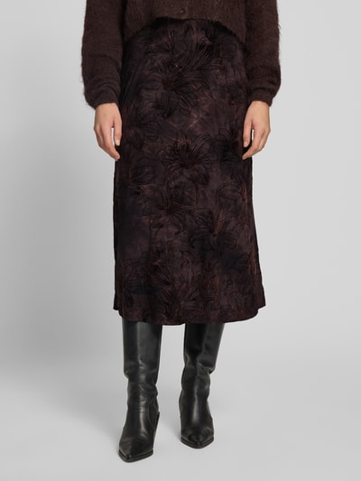 Frauenmodel trägt Midirock im Allover-Look Modell 'SESSOLANA' von FREE/QUENT, dunkle Farben, strukturierte Oberfläche, Nahaufnahme Unterkörper, Material-Mix mit Stretch-Anteil, gerader Schnitt, KI-modifiziertes Bild.
