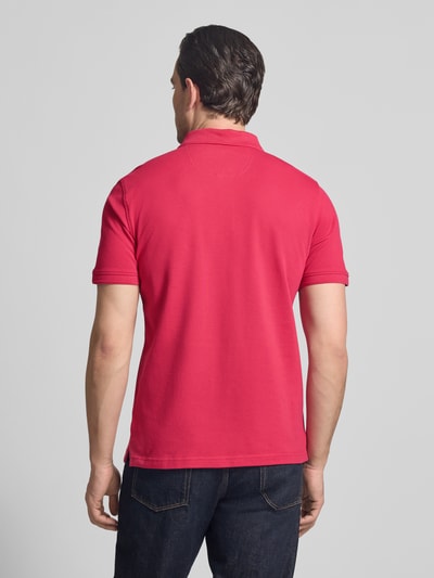 Männermodel trägt Slim Fit Poloshirt aus Baumwoll-Mix Modell 'Pete' von BRAX, rote Farbe, Rückenlänge 71 cm, Ganzkörperansicht Rückansicht.